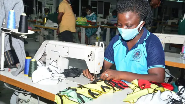 Pesin wey dey wear face mask for garment factory dey saw mas