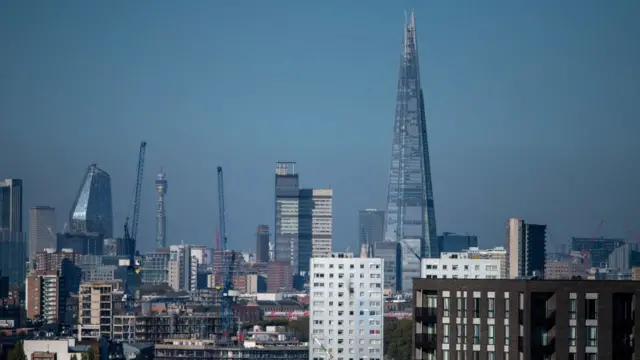 Fotografia colorida mostra prédios do distritocleo catra slotnegócioscleo catra slotLondres, incluindo um prédio alto com formatocleo catra slotum poliedro