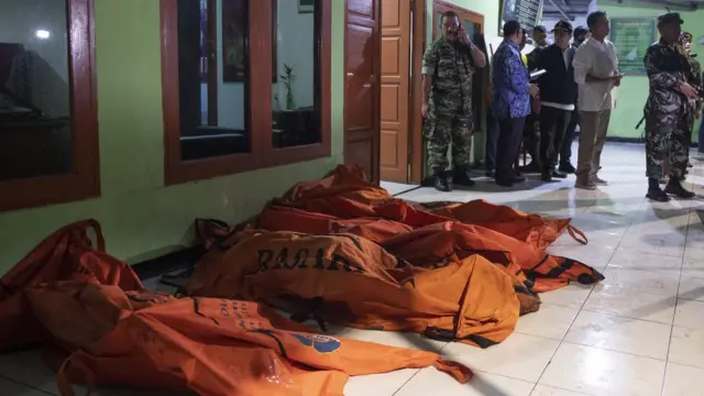 Sejumlah warga dan petugas berada di dekat kantong jenazah korban kebakaran pipa Pertamina Plumpang di Jakarta, Jumat (03/03)