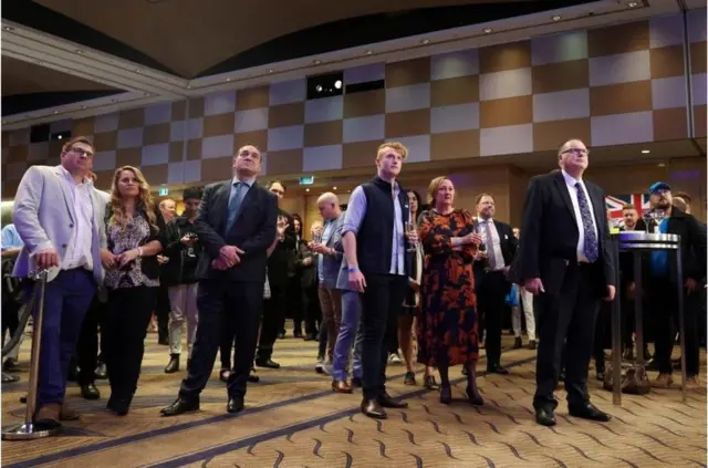 联邦大选结果公布前，澳大利亚自由党成员和支持者在屏幕上观看选举更新。