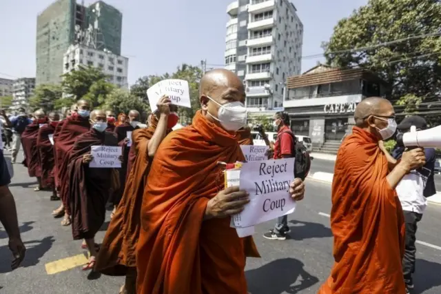 Myanmar Buddhist monks hold up placards as they march towards the United Nations(UN) office during a protest against the military coup in Yangon, Myanmar, 16 February 2021.