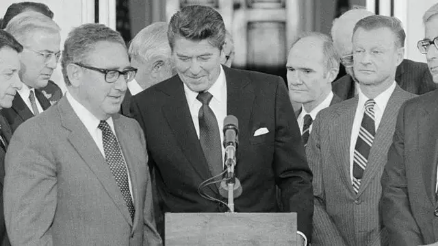 برژینسکی در کنار رونالد ریگان و کسینجر و تعدادی دیگر از مشاوران کاخ سفید پشت تریبون ایستادهاند ۱۹۸۱