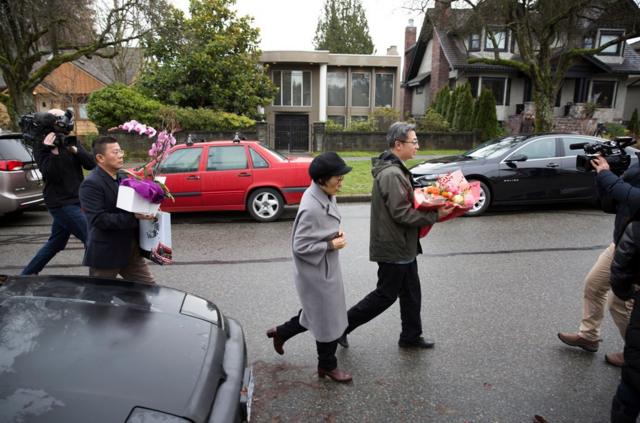 孟晚舟在12月11日獲得保釋後，乘坐外交車牌汽車抵達的人員攜帶鮮花前往孟晚舟在溫哥華的住處看望。