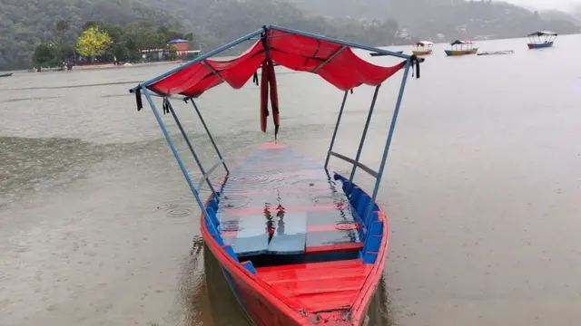 पोखराको फेवातालमा पानीको सतह बढेपछि किनारमा राखेका डुङ्गाहरू पानीले भरिएका छन्