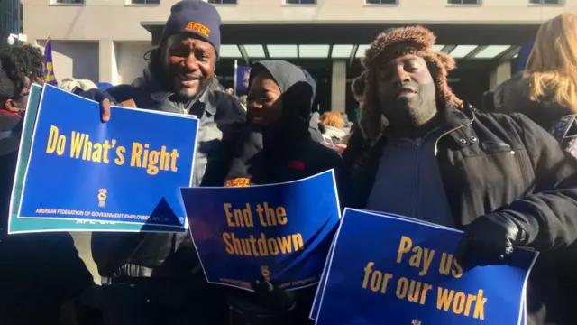 人口普查局雇员希尔（左）与同事参与抗议政府停摆的游行。