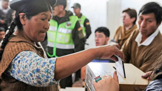 Uma mulher deposita seu voto na Bolívia