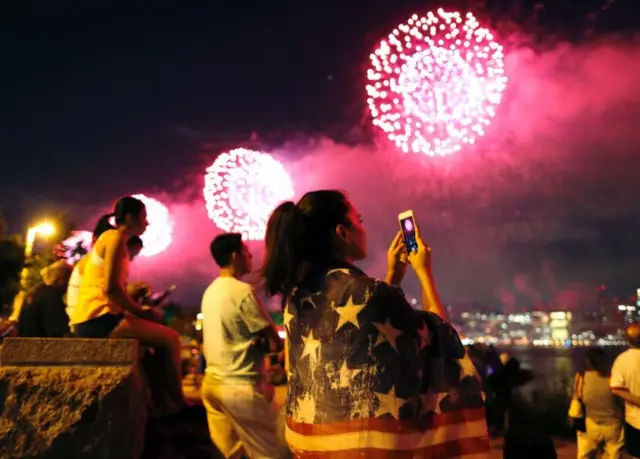 Varias personas observan los fuegos artificiales.