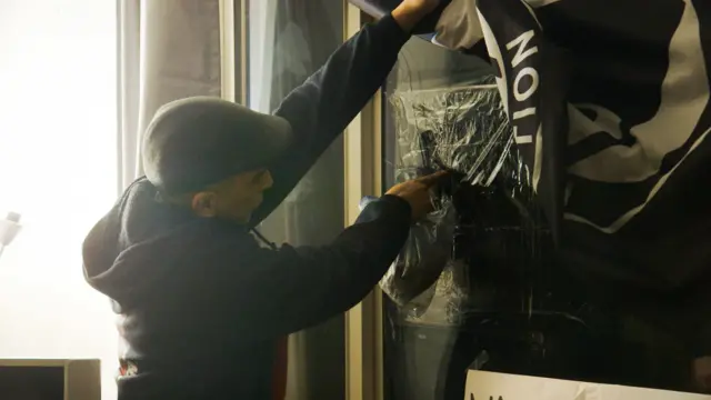 Luis señala el agujero en la ventana del frente de su casa