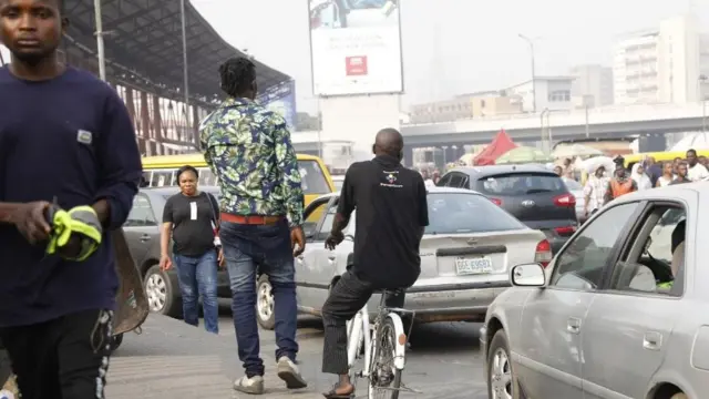 Daya daga cikin titunan birnin Legas a yayin da motoci ke wucewa mutane kuma na kokarin tsallaka titin