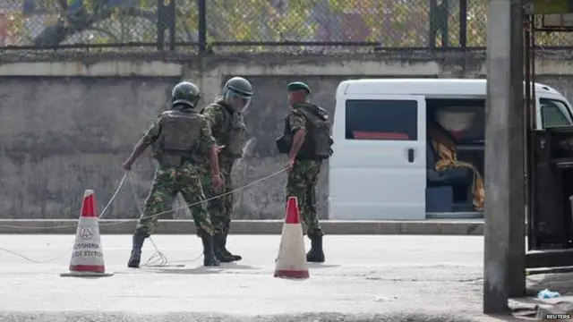 Bomb disposal experts cordon off an area surrounding the van as they prepare to defuse a suspected explosive device