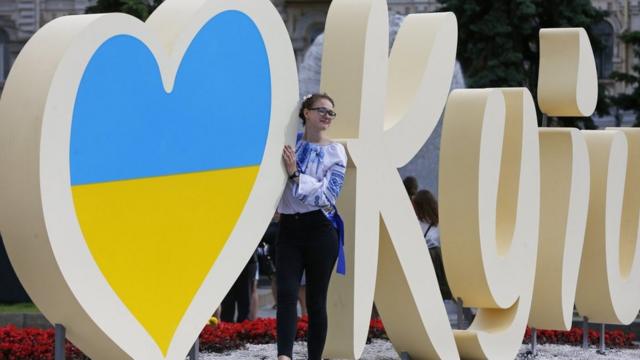 Дівчина фотографується біля знаку I Love Kyiv