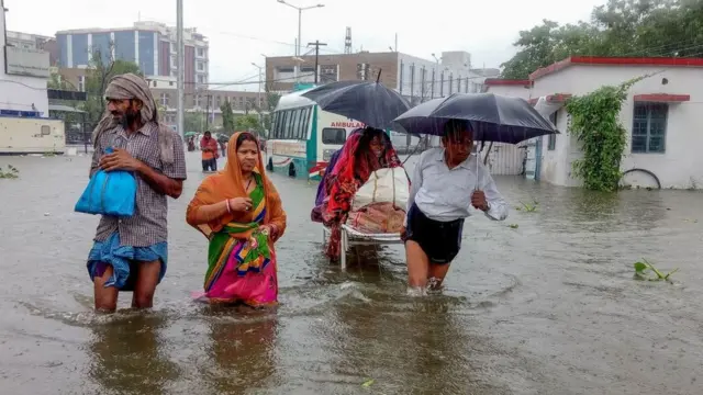 په عکسونو کې ځایي اوسېدونکي ښکاري چې د پتانه په پلازمېنه کې خلک په سړکونو روان دي او اوبه یې تر زنګنو پورې را رسېدلي دي.