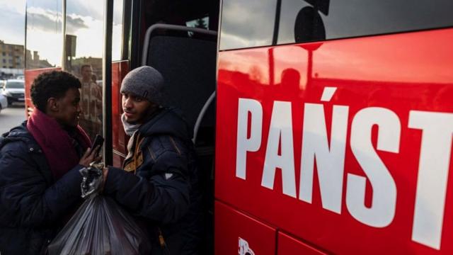 Des réfugiés montent dans un bus à la frontière polonaise