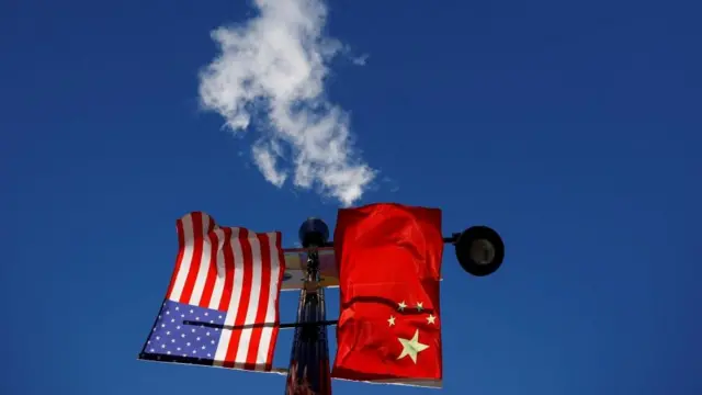 Flags of the United States and China fly from a lamppost