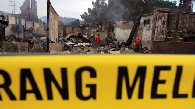 Seorang warga berjalan di lokasi bangunan terbakar di Area Bucen III Waena, Jayapura, Papua, Jumat (29/12/2023). Sebanyak 25 bangunan terbakar akibat massa pembawa jenazah mantan Gubernur Papua Lukas Enembe kembali rusuh.