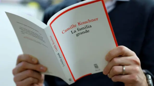 Hombre leyendo "La familia grande", de Camille Kouchner.