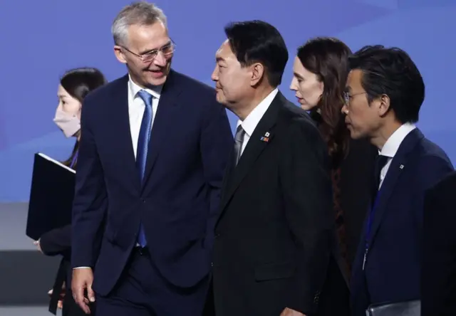 北约峰会首日新闻发布会后，北约秘书长延斯·斯托尔滕贝格（左）与韩国总统尹锡烈（中）交谈。右二为新西兰总理阿德恩。