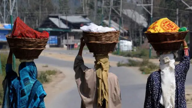 માથા પર ટોપલા લઈને જતી મહિલાઓ