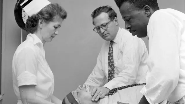 مريض في غرفة العمليات وحوله عدد من الأطباء