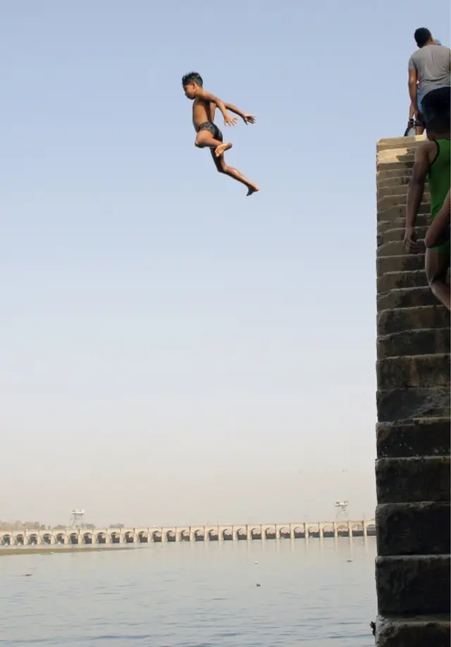 Children jump into the water of the Nile.