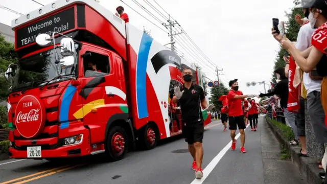 Sponsor truck and staff lead the relay before the runners" arrival during the first day of a Tokyo 2020 Olympic torch relay in the Saitama prefecture, amid the coronavirus disease (COVID-19) outbreak, in Wako, Japan July 6, 2021.