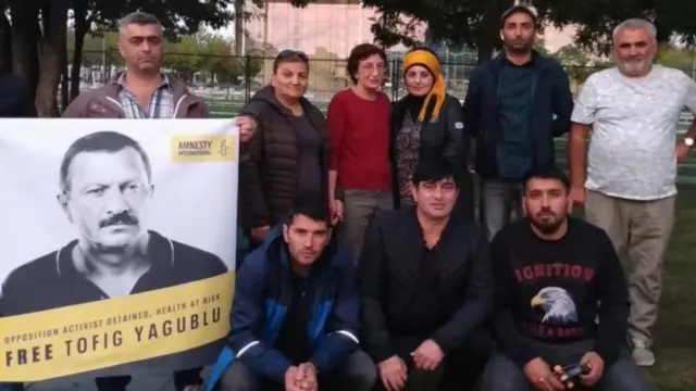 Групповое фото с акции. У одного из участников плакат с требованием освобождения политика Тофика Ягублу.