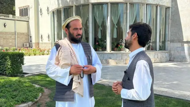 دو مرد در حال صحبت با لباس افغانی