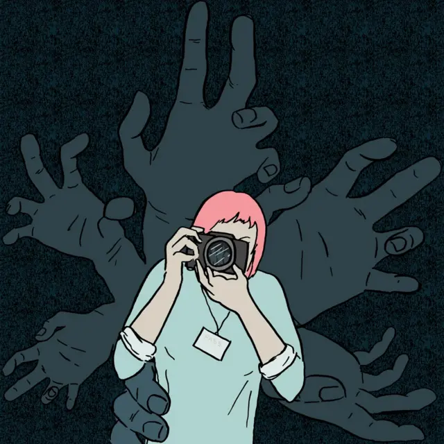 Velike šake iza žene sa fotoaparatom