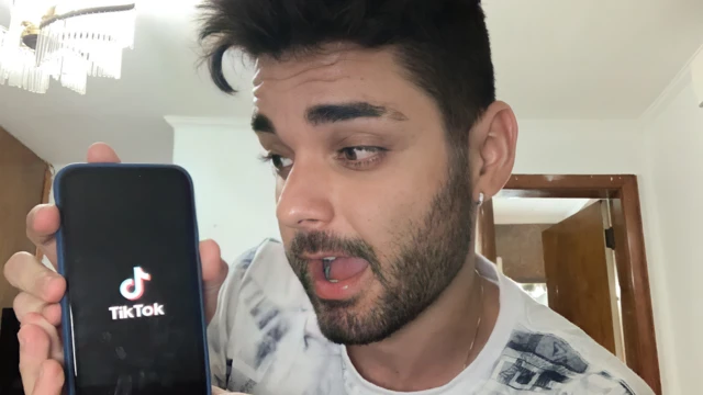 Fekin posa com um celular com logo do TikTok