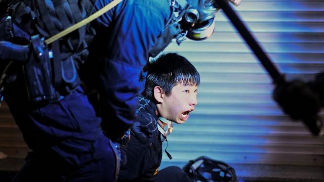 Un policía sujetando a un manifestante en Hong Kong.