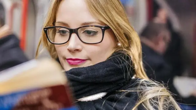 شابة تقرا في المواصلات