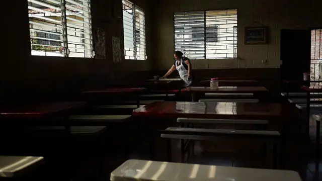 Una mujer salvadoreña limpia la mesa de un restaurante.