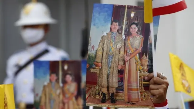 Thai royalist holds photographs of Thai King Maha Vajiralongkorn Bodindradebayavarangkun (L) and Thai Queen Suthida (R) during a pro-monarchy demonstration outside the Grand Palace in Bangkok, Thailand, 01 November 2020