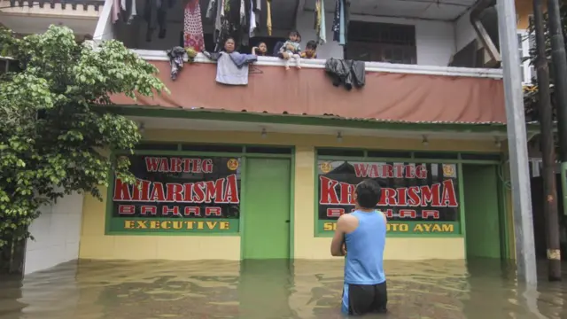 Sejumlah warga mengungsi di lantai dua rumahnya saat banjir di kawasan Kampung Makasar, Jakarta Timur, Selasa (25/02).
