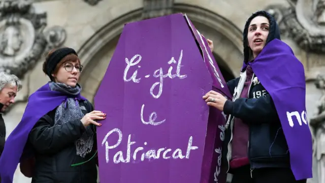 "Здесь лежит патриархат" - написано на бутафорском гробу, который несут участницы демонстрации в Париже