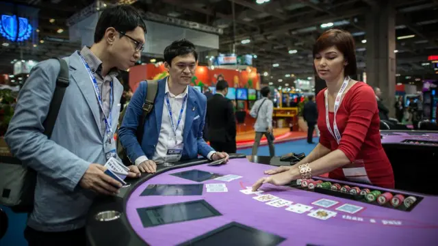 澳门一场博彩展览上参观者在模拟赌台上耍乐(资料图片)