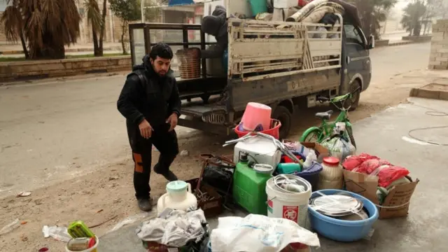 A man loads a truck as Syrian government forces bear down on Maaret Al-Numan