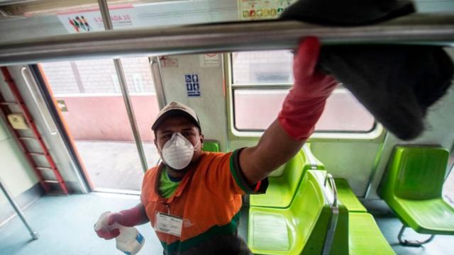 Hombre limpia el interior de un bus en México