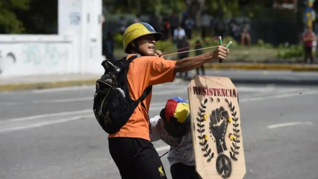 Un manifestante ataca a las fuerzas antidisturbios.