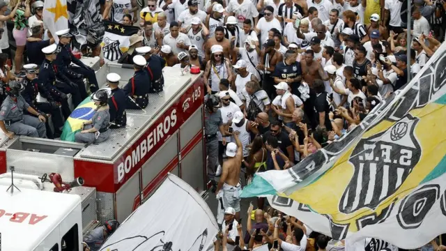 El féretro con los restos de Pelé en un camión de bomberos rodeado por miles de fans