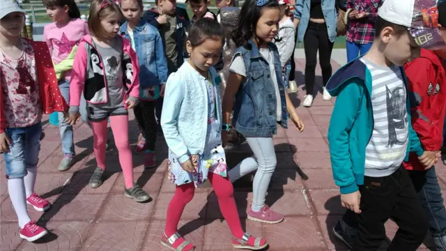 เด็กหลายคนเดินจูงมือเรียงเป็นแถว ซึ่งที่ประเทศนี้สามารถพบเห็นคนหลายหลายเชื้อชาติ ตั้งแต่คาซัค ยูเครน รัสเซีย เยอรมัน เพราะเป็นปนะเทศที่อยู่ระหว่างรอยต่อของทวีปเอเชีย-ยุโรป