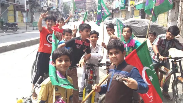 పార్టీల జెండాలతో బాలలు