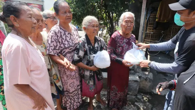Warga antre untuk mendapatkan bantuan sembako di Kelurahan Pojok, Kota Kediri, Jawa Timur, Selasa (07/04).
