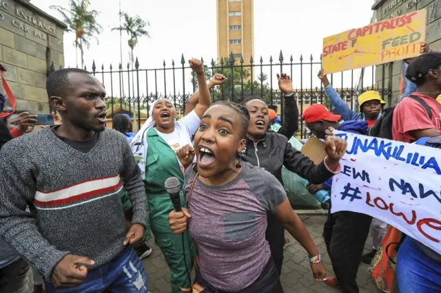 Qaala'insi jireenyaa ardii Afirkaa irratti miidhaa qaqqabsiisaa jira waan ta'eef Kibxata darbe magaalaa Keenyaa, Naayiroobii keessatti aktivistoonni paarlaamaa biyyattii duratti bahanii yeroo mormii dhageessisan, Caamsaa 17, 2022.