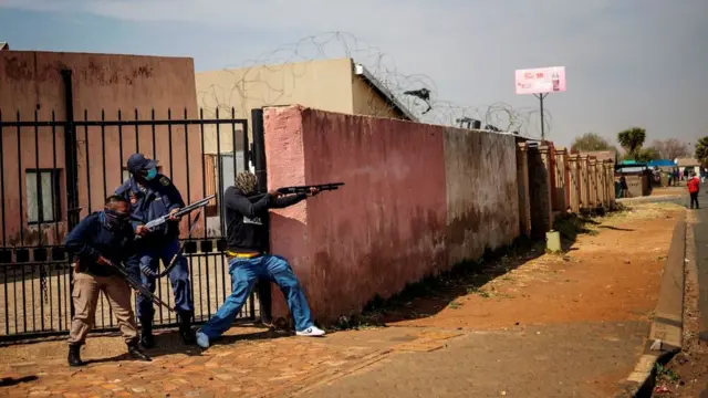 Des membres du service de police sud-africain (SAPS) tirent des balles en caoutchouc sur des habitants d'Eldorado Park, près de Johannesburg, le 27 août 2020