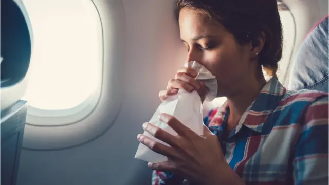 Mulher vomitando durante voo