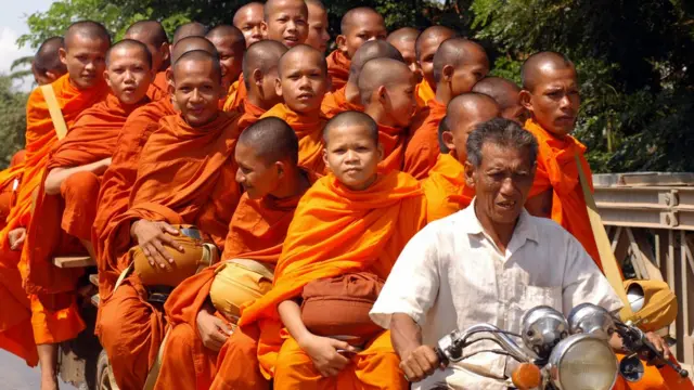 एक मोटर कार्ट पर बैठे बौद्ध भिक्षू.