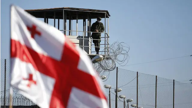 Флаг Грузии на фоне Руставской тюрьмы