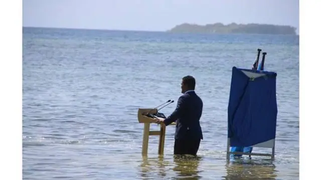 Homemroleta de números de 1 a 20terno submerso até o joelho na água do mar discursaroleta de números de 1 a 20um palanque também submerso sob um céu azul