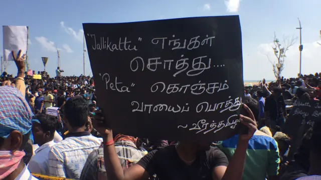 போராட்ட களத்தில் பதாகையுடன் ஆர்ப்பாட்டக்காரர்கள்